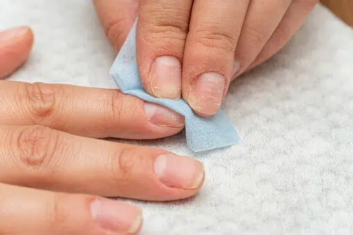 removing acrylic nails with nail drill by a manicurist